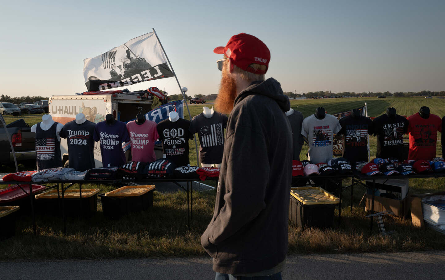Vendors sell campaign-related merchandise before the start of a rally hosted by Republican presidential nominee former US president Donald Trump at Dodge County Airport on October 6, 2024, in Juneau, Wisconsin.